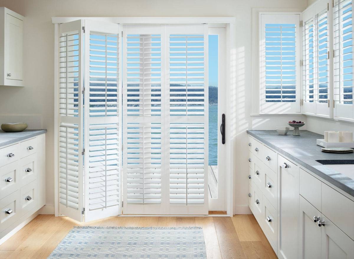 Hunter Douglas Palm Beach™ PolySatin™ Shutters decorating kitchen windows and sliding door near Miami, FL